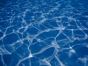 プールの水中を走る光の斑模様と波紋のテクスチャー