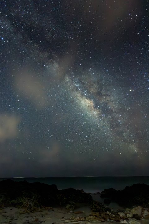 星々と天の川が輝く海岸線の夜空～砂浜と磯の夜間撮影