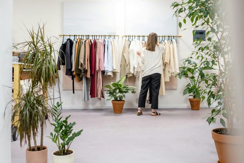 ラックの衣類を直す女性